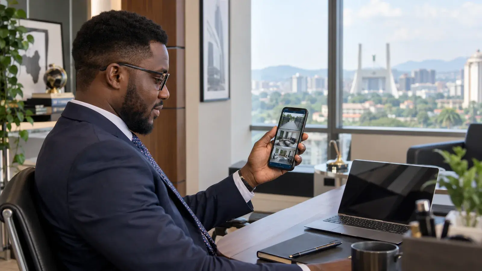 Business owner monitoring multiple CCTV camera feeds on his phone from his Abuja office