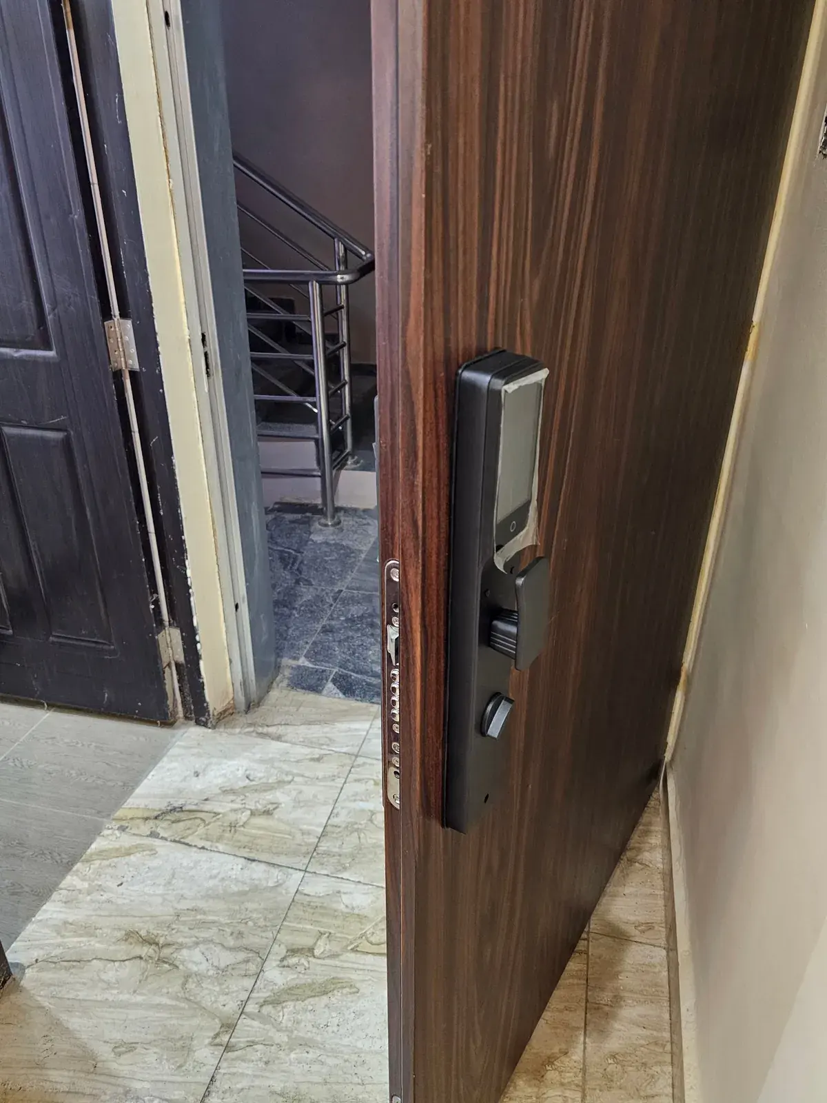A newly fitted MYMAiGUARD smart lock on an open door, with several locking bolts visible along the door edge